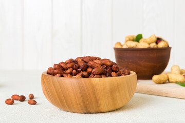 Fresh healthy peanuts in bowl on colored table background. Top view Healthy eating bertholletia concept. Super foods