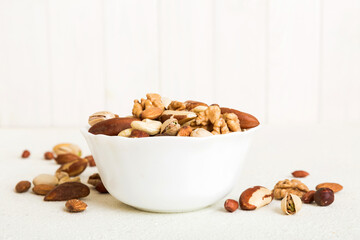 mixed nuts in bowl. Mix of various nuts on colored background. pistachios, cashews, walnuts, hazelnuts, peanuts and brazil nuts