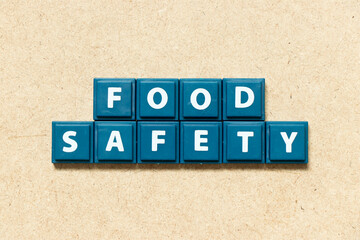 Tile alphabet letter in word food safety on wood background