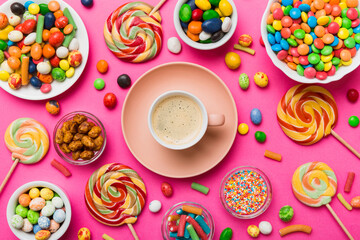 Coffee cup with chocolates and colored candy. Top view on table background with copy space