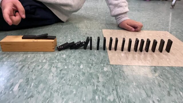 Slow motion dominos falling on floor