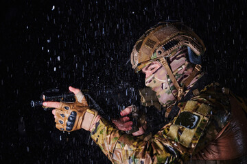 Army soldier in Combat Uniforms with an assault rifle, plate carrier and combat helmet going on a...
