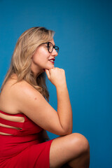 Portrait of mature woman wearing red outfit sitting with hands on chin. Positive and confident person.
