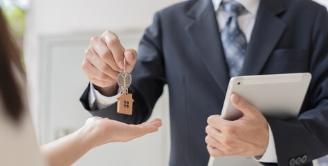 lease, rental and selling home. Real estate agent manager smile holding key for new owner.  rent house, Sales, loan credit financial, insurance, Seller, dealer, installment,  buy, sell, move in