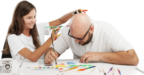 Painting concept. Schoolgirl painting with father during therapy at home with his tutor with learning and having fun together.