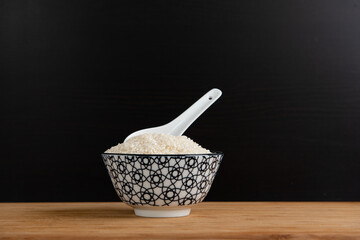 Bol de riz cru de style asiatique sur une planche en bois