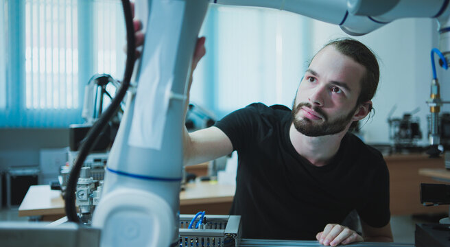 Industrial robotics stylish caucasian male engineers, research and development, working analyzing and evaluating innovation technology robotic systems in research laboratory.