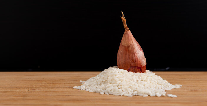 Riz et échalottes sur une planche de bois - ingrédients de cuisine - risotto