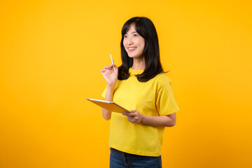 young Asian woman wearing yellow t-shirt and jeans showing happy smile while using digital tablet, displaying thoughtful expression and creative idea. education technology innovative thinking concept.