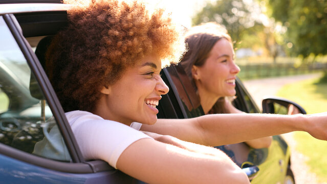 Two Female Friends Or Same Sex Couple In Car On Road Trip Vacation Together Looking Out Of Window