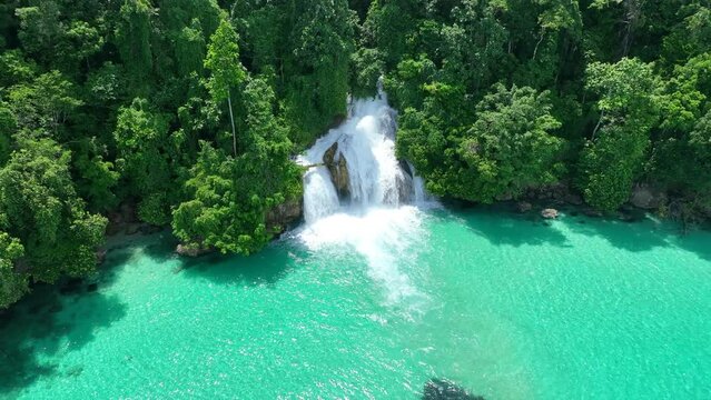The scenic Momon waterfall tumbles from the primordial rainforest of West Papua into the shallow sea. This spectacular waterfall is found about a day's sail north of Kaimana.  