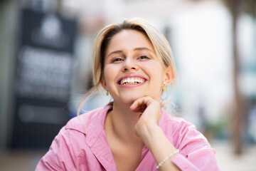 Portrait of attractive young woman sitting outside