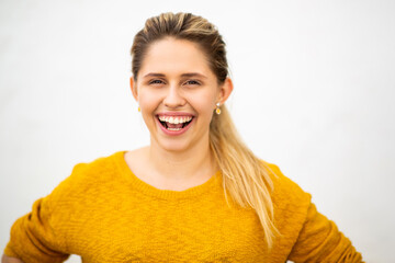 Beautiful young woman laughing against white background