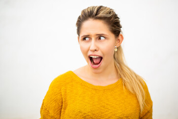 Pretty young woman with surprised expression looking away