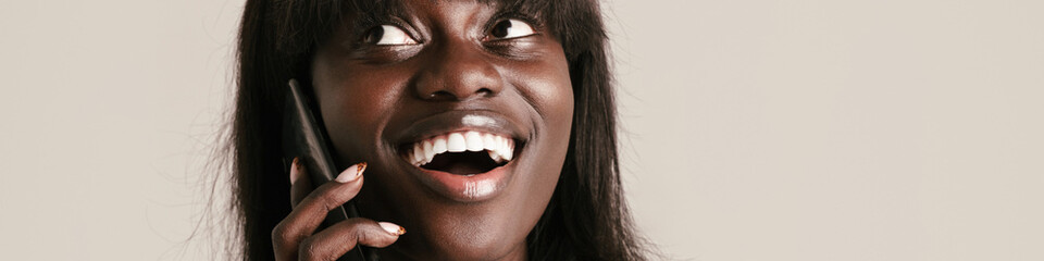 Young beautiful smiling african woman with bob haircut talking phone