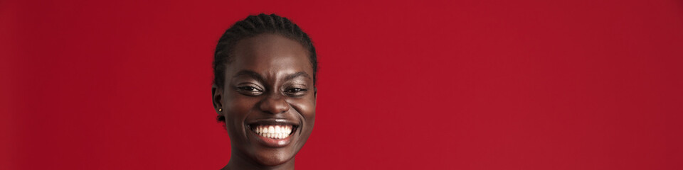 Fototapeta premium Young beautiful enthusiastic african woman with braided hair playing phone