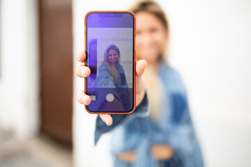 Woman talking selfie with her mobile phone back camera