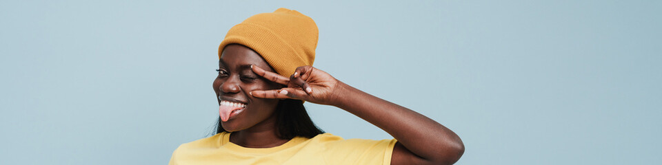 Young beautiful smiling african woman in t-shirt and winter hat