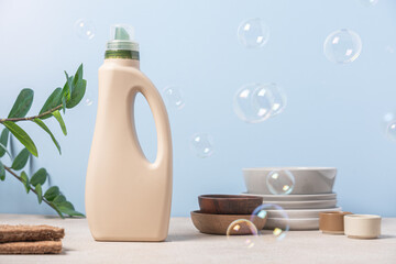 Eco-friendly dishwashing. Bottle with detergent and bamboo eco sponges on blue background with soap bubbles