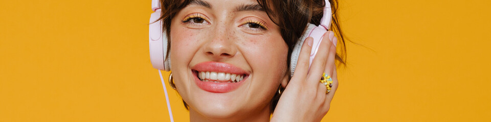 Young beautiful smiling short-haired stylish woman in headphones with phone