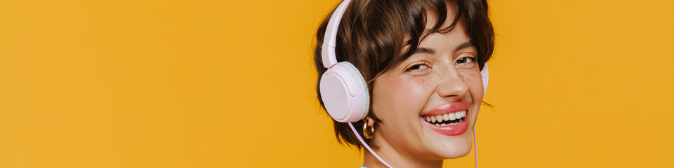 Portrait of young beautiful smiling woman in headphones with phone