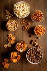 Many bowls with different salty snacks - chips pretzels nuts