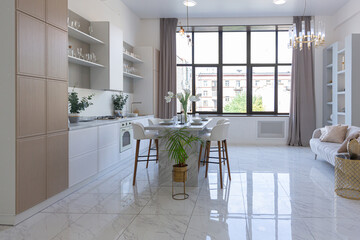 minimalistic light elegant luxury design of a modern spacious studio apartment with kitchen area, bedroom and huge mirror behind the couch. tiles on the floor and high ceiling.