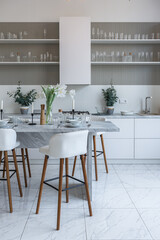 close view kitchen with dinning marble table and hight bar stools in minimalistic light elegant luxury design of a modern spacious studio apartment in soft pastel beige colors