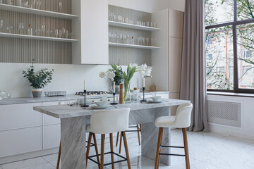 close view kitchen with dinning marble table and hight bar stools in minimalistic light elegant luxury design of a modern spacious studio apartment in soft pastel beige colors