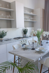close view kitchen with dinning marble table and hight bar stools in minimalistic light elegant luxury design of a modern spacious studio apartment in soft pastel beige colors