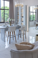 minimalistic light elegant luxury design of a modern spacious studio apartment with kitchen area, bedroom and huge mirror behind the couch. tiles on the floor and high ceiling.