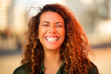 Cheerful young latin woman standing outside