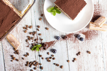 Tiramisu dessert. A plate with delicious tiramisu on a light background