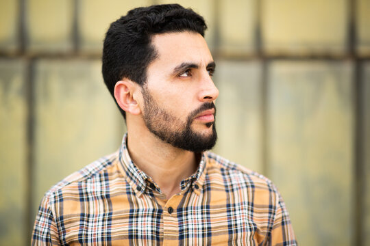 Young arabic man looking away with serious expression