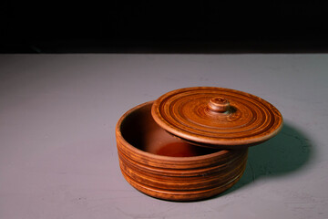 Brown empty clay pot with lid. Clay decor on a concrete surface. Decorative dishes of brown color.