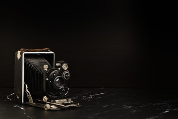 Ancien appareil photo vintage à soufflet sur fond noir - appareil analogique 