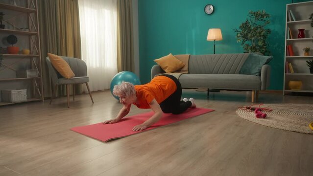 Elderly woman doing stretching after a workout. A woman does an exercise for her back and spine. Side view. Keeping body in tone.