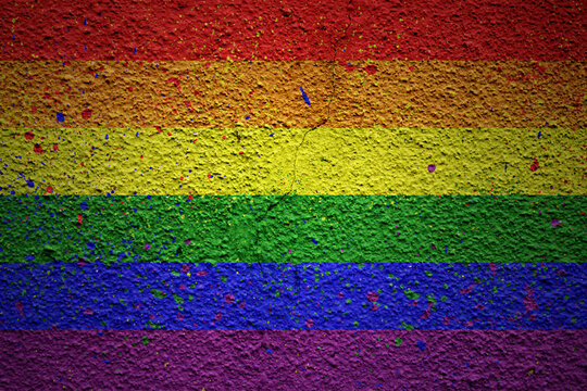 painted big rainbow gay pride flag on a massive old cracked wall