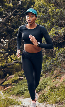 Fitness, black woman and workout in forest for health wellness in sportswear. Commitment or exercise, motivation or running and African female athlete training for marathon in woods outdoor.