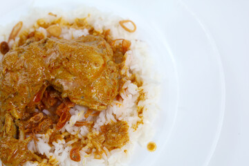 Top view a plate of warm white rice topped with chicken curry. Padang Rice with chicken curry.