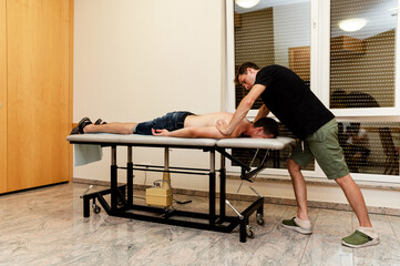 masseur doctor makes body massage to a middle-aged man at home. prophylactic massage. examination...