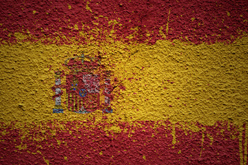 painted big national flag of spain on a massive old cracked wall