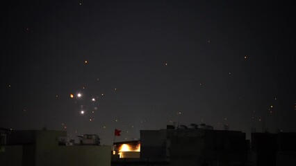 buildings at night with fireworks, lights and sky lanterns showing the celebrations in the old city of delhi jaipur for makar sankranti, diwali, dussera, independence republic day in India