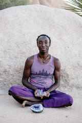 Photographs of a young black gay man practicing Reiki in the desert.  - 619525946