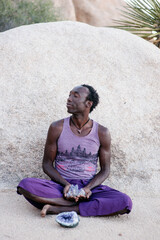 Photographs of a young black gay man practicing Reiki in the desert.  - 619525966