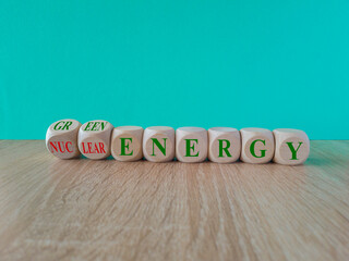 Nuclear or green energy symbol. Turned wooden cubes and changes concept green words nuclear energy...