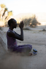 Photographs of a young black gay man practicing Reiki in the desert.  - 619526352