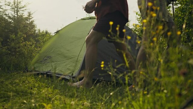 Vacation, Two tourists set up a tent in a forest area to spend the night In mountainous area. Fitness woman Resting from everyday routine work mastering new techniques testing herself in the wild, man