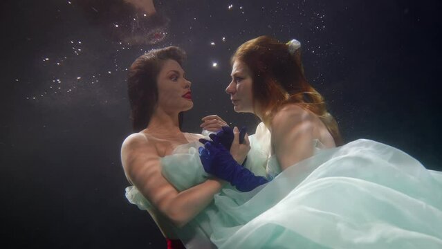 loving couple of beautiful women lesbians floating underwater, dream and fantasy about two ladies