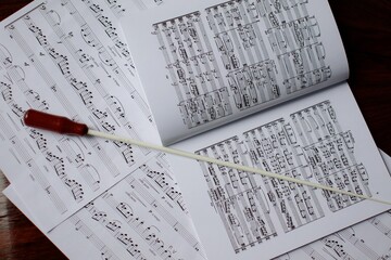 Conductor baton on music score close-up